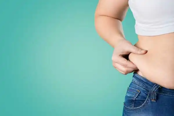 Image of woman pinching her love handles to show weight gain Ravensthorpe